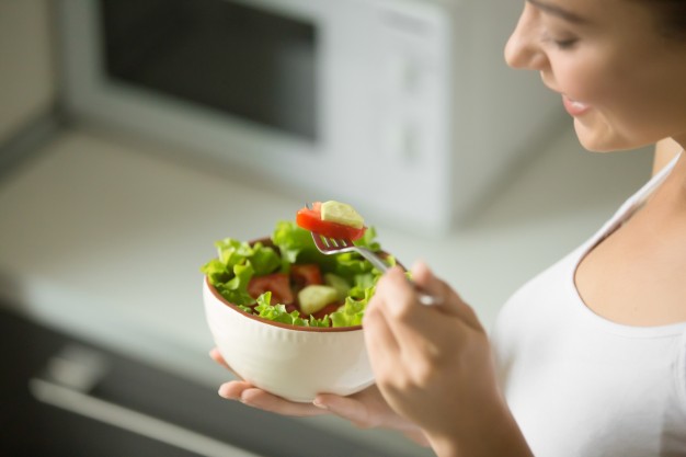 bowl of fresh green salad hold in female hands 1163 2253